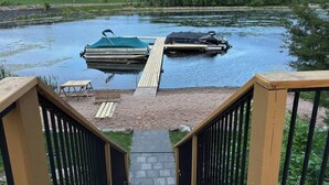 A dock with two boats, a wooden deck, and a small outdoor seating area. - Nordic Harbor | Haus Cabin (Center City)