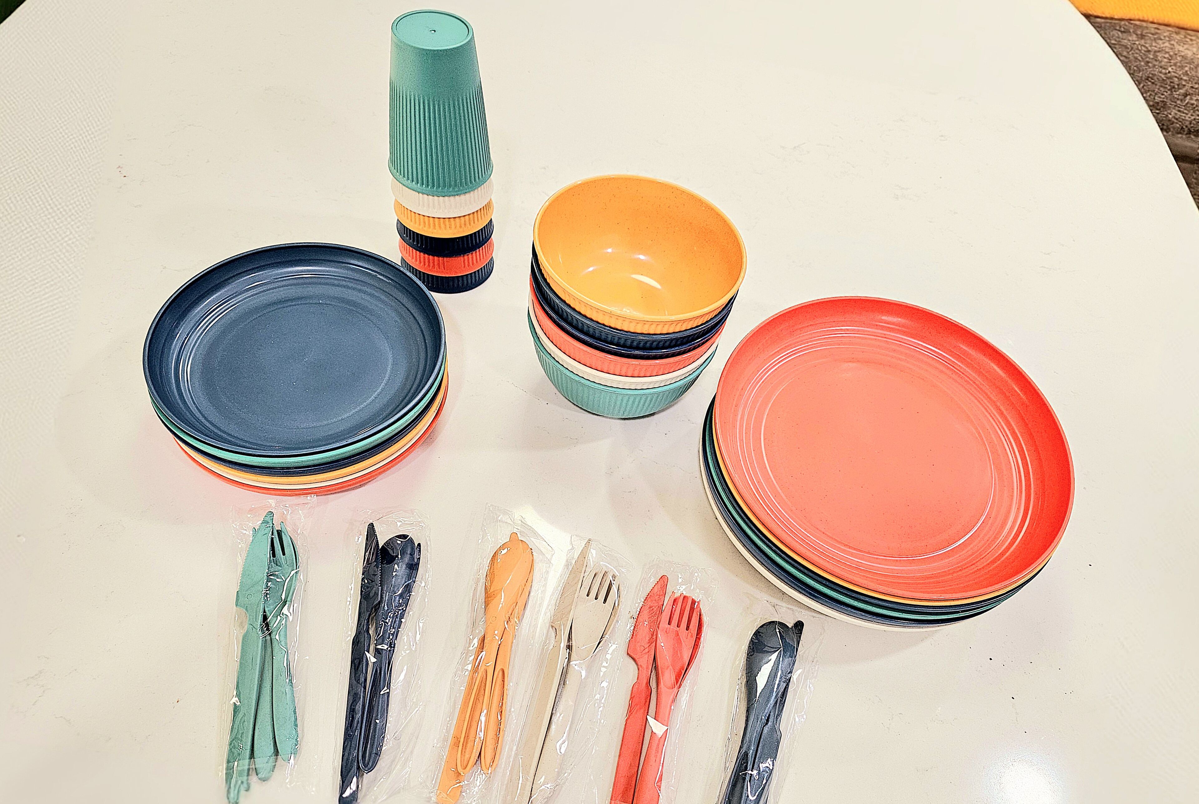 Uma mesa com pratos empilhados e talheres.