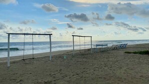 A beach with a swing set and a bench area. - Hostal Playa Azul (Corinto)
