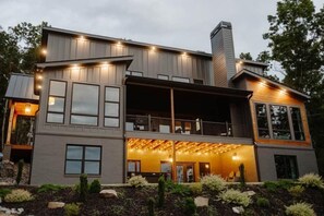 Una casa moderna de dos pisos con un espacio exterior cubierto y un garaje amplio.