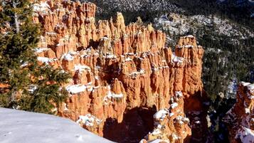 Paesaggio montano innevato con formazioni rocciose rosse caratteristiche.