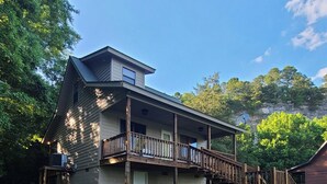 A two-story house with a balcony, a deck, and a fire pit in the yard. - Beautiful Secluded Cabin on the White River (Calico Rock)