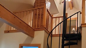 A wooden staircase with a black handrail leading to a lofted area. - Beautiful Secluded Cabin on the White River (Calico Rock)