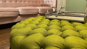 Un pouf verde con un tavolino e una coppia di forbici sopra.