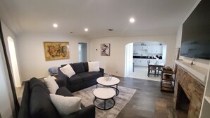 Un salon moderne avec un canapé d’angle, une table basse et une cheminée.