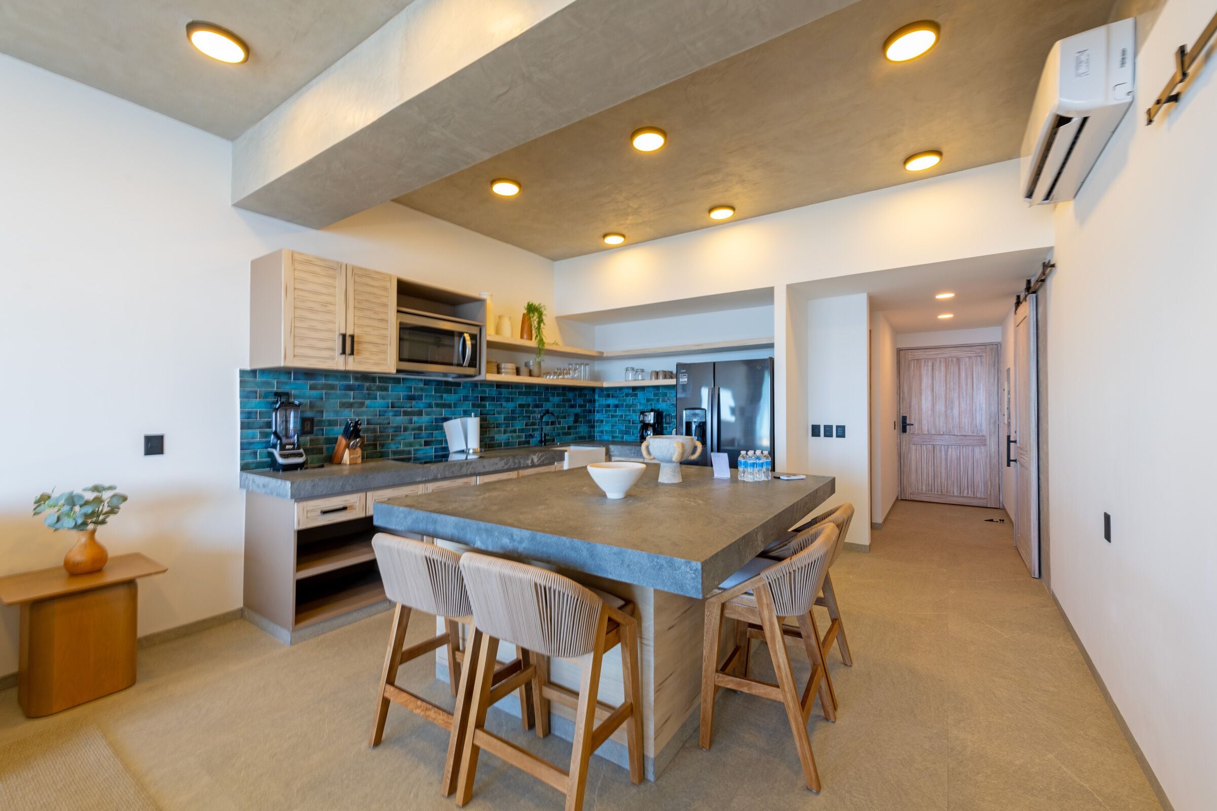 A modern kitchen with a large island, built-in appliances, and a clean, minimalist design.