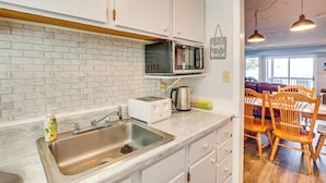 A kitchen with white cabinets, a stainless steel sink, a toaster, and a microwave. - Hike, Ski & Fish! Sunset-View Condo in Beech Mtn (Beech Mountain)