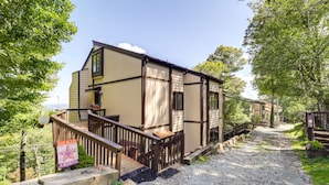 A two-story building with a wooden deck and a gravel path leading to the entrance. - Hike, Ski & Fish! Sunset-View Condo in Beech Mtn (Beech Mountain)