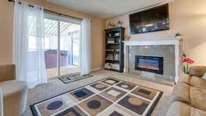 Een woonkamer met een open haard, een bank, een salontafel en een boekenkast.