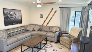 A modern living room with a sectional sofa, a coffee table, and a fireplace. - Fireside Condo at the Village - Sleeps 4 - Newly Remodeled (Mammoth Lakes)