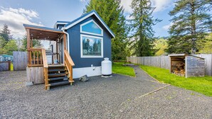 En hyggelig, etplans hytte med træterrasse og overdækket terrasse.