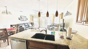 A kitchen with granite countertops, a dishwasher, and a sink. There are pendant lights above the counter, and a ceiling fan. - The Blue Llama- on the Guadelupe river! 2 pools, 1 heated, 4 hot tubs (New Braunfels)