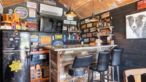 Um bar com balcão de madeira, banquetas pretas e um letreiro vintage Chevrolet.