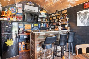 Eine Bar mit einer Holztheke, schwarzen Barhocker und einem Schild mit der Aufschrift Vintage Chevrolet.