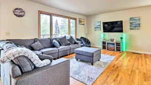 Una sala de estar moderna con un sofá modular, un reposapiés y una chimenea.