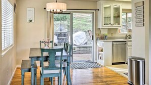 Una cocina con comedor, vistas al exterior y un cubo de basura.