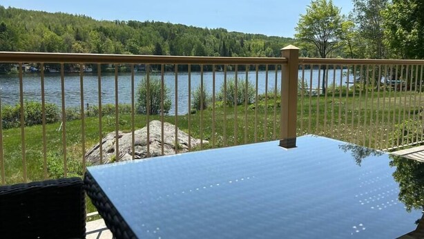 Una terraza con vistas a un lago y un bosque.