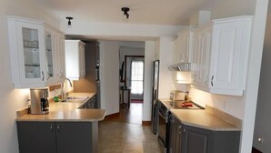 Una cocina moderna con armarios grises, una isla central y vistas al comedor.