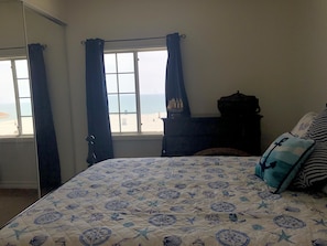 A bedroom with a bed, a dresser, and a window with curtains. - Seaside Retreat Apartment with Oceanview - Upstairs  (San Clemente)