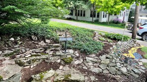 A stone pathway with a sign, surrounded by greenery and a residential street. - Spacious 5 Bedroom House On Double Lot In Lakeside One Block From The Lake! (Lakeside Marblehead)