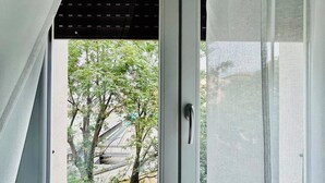 A window with a view of trees and a building outside. - MyArenaVerona － large apartment in the heart of Verona (Verona)