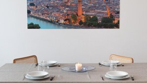 A dining table set with plates, glasses, and cutlery, with a candle centerpiece. - MyArenaVerona － large apartment in the heart of Verona (Verona)
