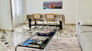 A living room with a coffee table holding board games, a sofa, and a dining table with chairs. - MyArenaVerona － large apartment in the heart of Verona (Verona)