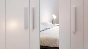A bedroom with a bed, white walls, and a bedside lamp. - MyArenaVerona － large apartment in the heart of Verona (Verona)
