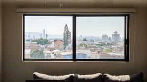Una habitación con un amplio ventanal con vistas a un paisaje urbano.
