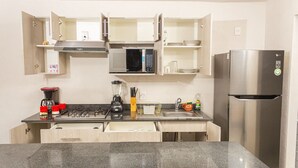 A compact kitchen with a microwave, refrigerator, and a coffee maker.