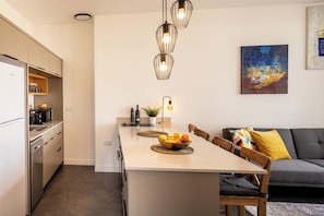 Une cuisine moderne avec un îlot central, un coin repas et un canapé.
