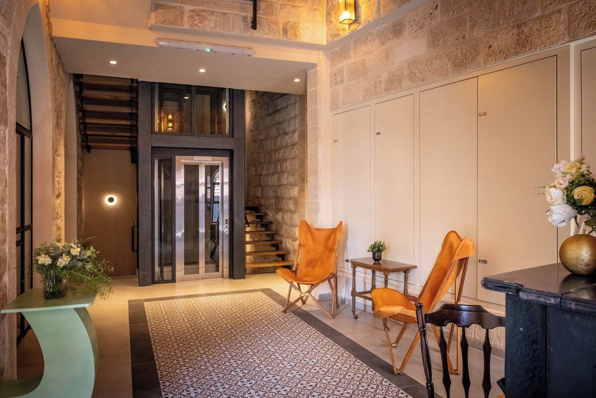 Eine moderne Lobby mit Treppe, Sitzgelegenheiten und einer Rezeption.