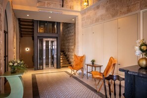 A modern interior with a staircase, seating area, and a reception desk.