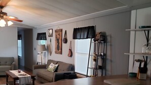 Une cuisine moderne avec un îlot central en bois, un coin repas avec un canapé et un salon avec un divan.