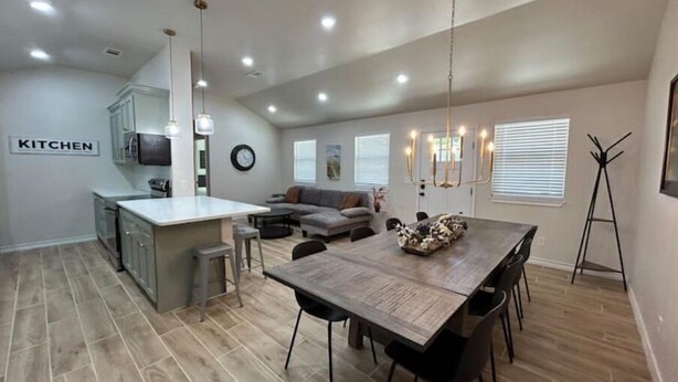 A spacious living area with a dining table, kitchen area, and a coat rack. - The CanyINN (Canyon)
