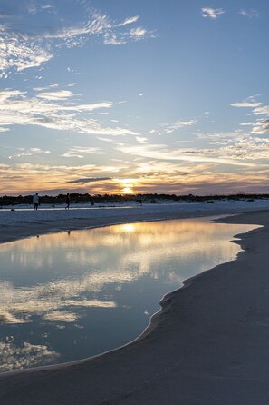 Un lac gelé dont la surface reflète clairement le ciel et le coucher de soleil.