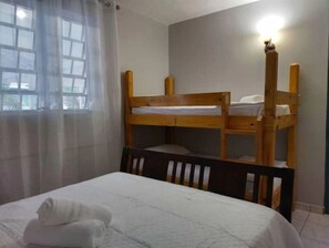 A bunk bed with a wooden frame, a white mattress, and a headboard with a light fixture. - Cabanas Playa Santa/ Apto.A/Billar/ Piscinas/ Energía Renovable (Guanica)