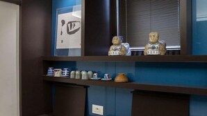 A kitchen with a sink, shelves with containers, and two figurines. - Luxury Suite Fori Imperiali (Roma)
