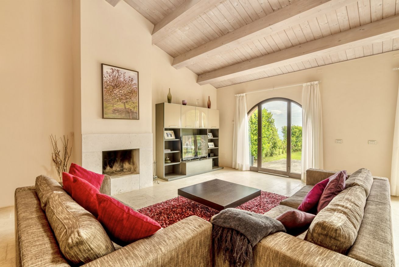 A spacious living room with a fireplace, a large sofa set, and a bookshelf.