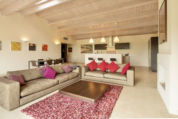 A modern living room with two sofas, a coffee table, and a red patterned rug.