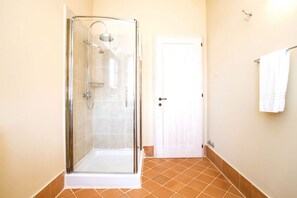 Une salle de bain avec une douche à parois de verre, une porte blanche et un porte-serviettes.