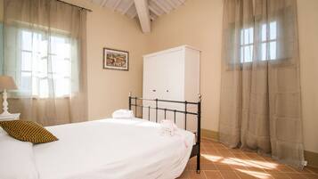 A bedroom with a bed, a wardrobe, and a nightstand.
