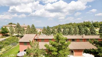 A residential area with multiple houses, a clear sky, and a distant view of the sea.
