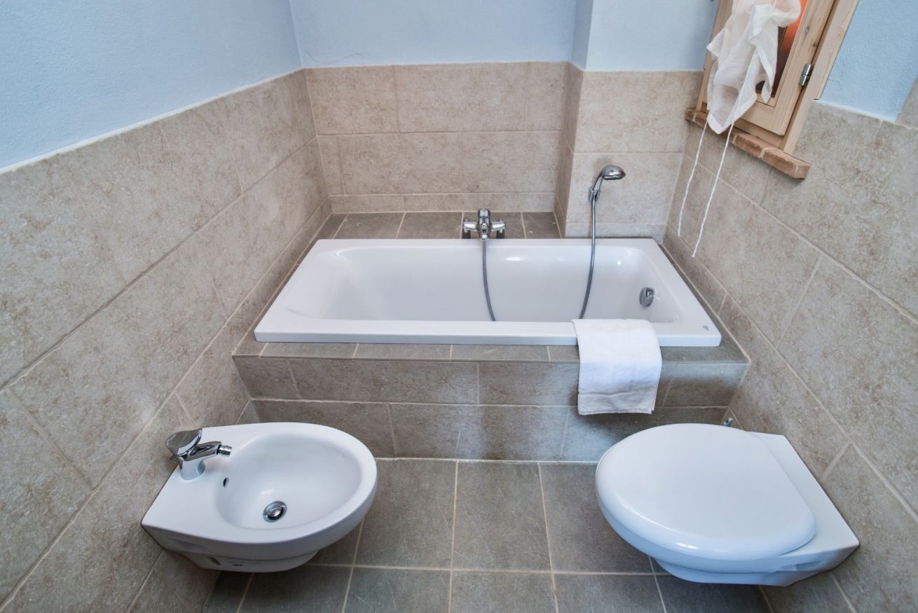 Een badkamer met een bad, een wastafel en een toilet.