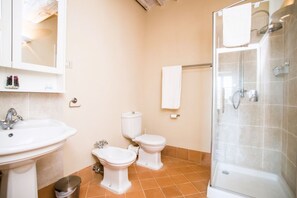 A bathroom with a sink, two toilets, a bidet, a shower, and a towel rack. - Elegant ground floor apartment of 92 m2, composed of a large living room with fireplace, kitchen complete with dishwasher, microwave oven, electric oven, coffee machine, kettle, fridge and freezer, internal and external dining area, a double bedroom with (Trequanda)