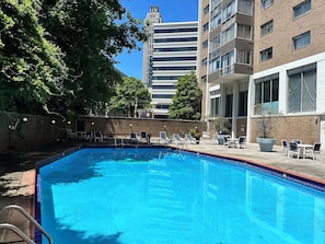 Relax by the pool surrounded by lush greenery and comfortable lounge seating.