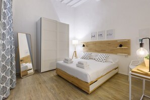Une chambre à coucher comprenant un lit, une table de chevet, une lampe et une armoire.