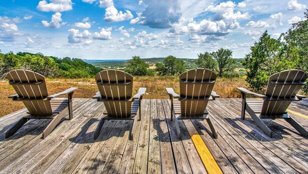 Four Adirondack chairs on a wooden deck with a scenic view. - *New| Stunning Views| Sleeps 10 (Fredericksburg)