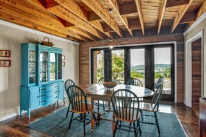 A dining area with a wooden ceiling, a large window with a view, and a blue cabinet. - *New| Stunning Views| Sleeps 10 (Fredericksburg)