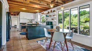 A modern kitchen with a central island, white cabinetry, and a view of greenery outside. - *New| Stunning Views| Sleeps 10 (Fredericksburg)